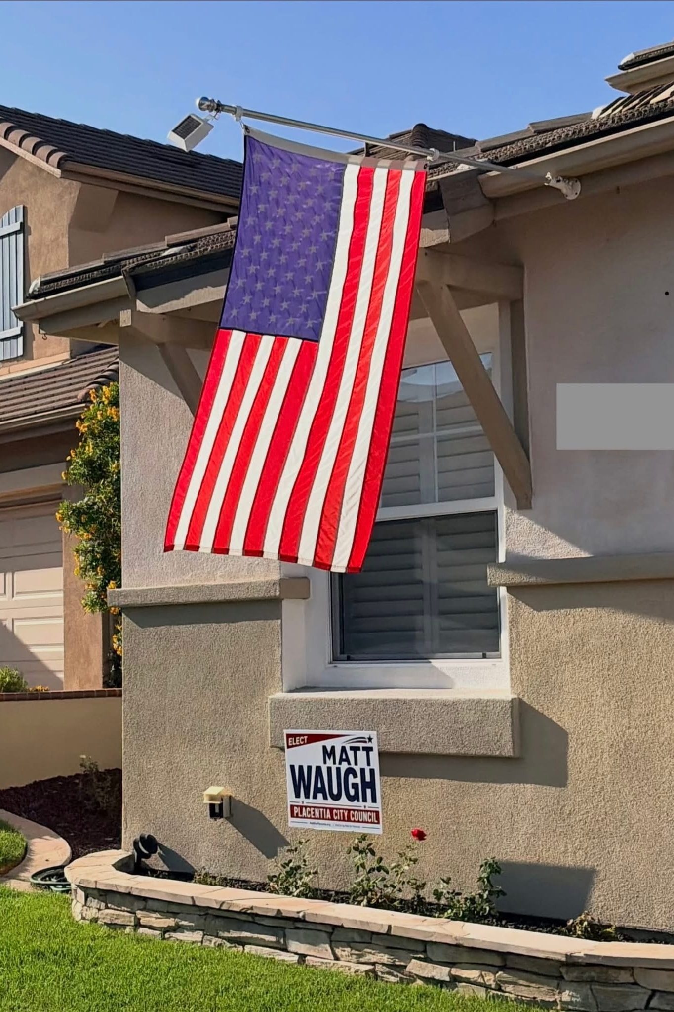 Elect Matt Waugh campaign yard sign displayed on a home with an American flag